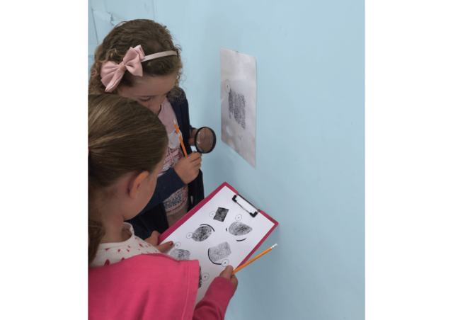 Two girls looking at fingerprints